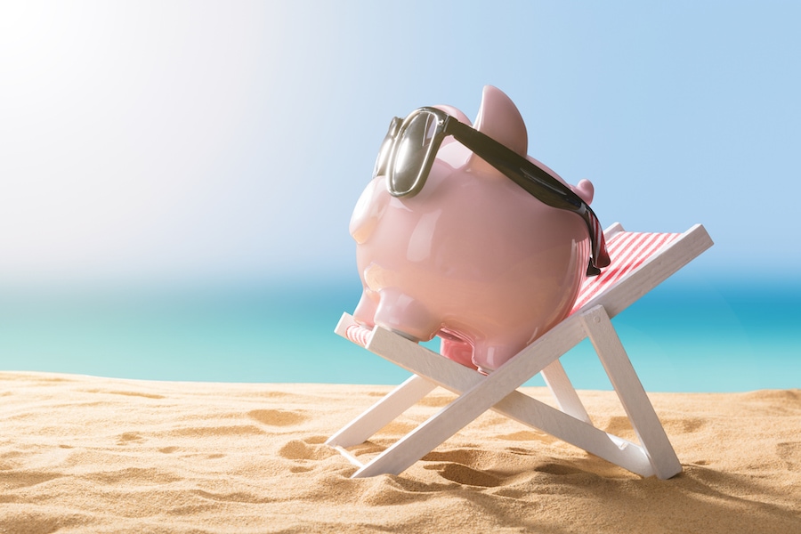 Close-up Of A Pink Piggy Bank Wearing Sunglasses Relaxing On Deck Chair.