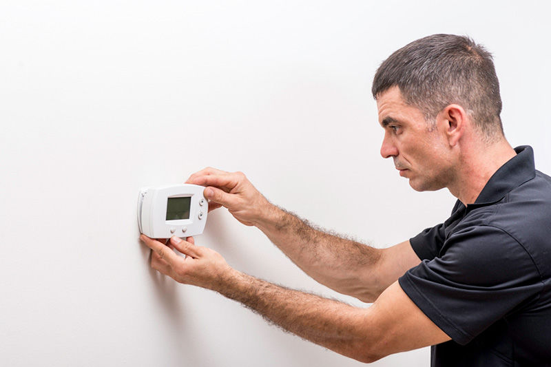 Man Fixing Thermostat