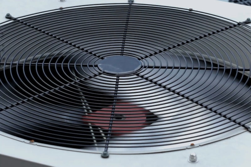 Up close shot of an air conditioner unit fan running.